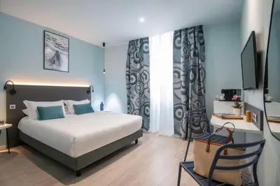 a bedroom with a bed and a desk and a television at Best Western Alba in Nice