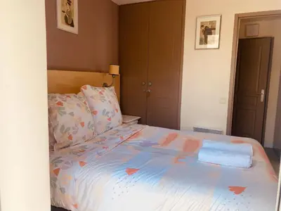 a bedroom with a bed with a blue comforter at Sunny Home Costa Plana-Monaco -Cap D'Ail in Cap d'Ail