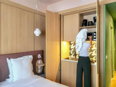 a person is looking into a cupboard in a bedroom at Hotel Aparthotel AMMI Nice Lafayette in Nice