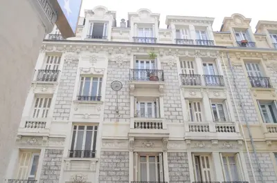 a building with a clock on the side of it at Appartement carre d'or in Nice