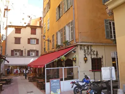 a street with a store with a red awning on a building at Apartment Miralheti by Interhome in Nice