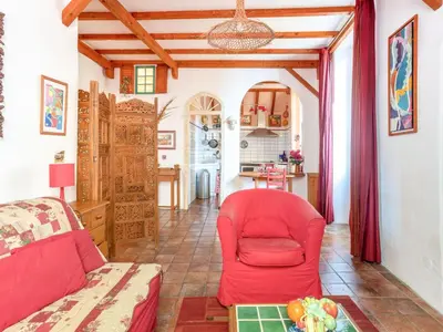 a living room with a red chair and a table at Apartment Miralheti by Interhome in Nice
