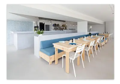 a dining room with a long table and chairs at Hôtel Le Versailles in Villefranche-sur-Mer
