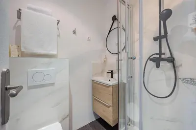 a bathroom with a shower and a sink at Hotel Select in Beaulieu-sur-Mer