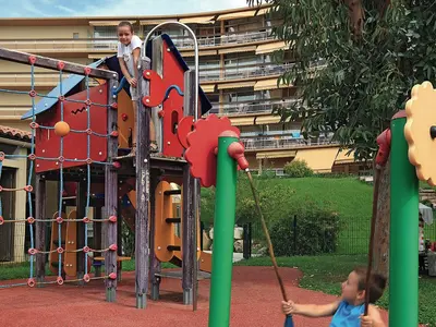 a man and a child on a playground at Residence Heliotel Marine - maeva Home in Saint-Laurent-du-Var