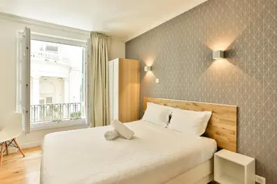 a bedroom with a large white bed with a window at Nice Home - Studios Lido in Nice