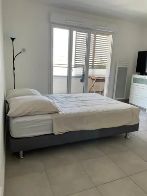 a bedroom with a large bed and a television at beau studio in Nice