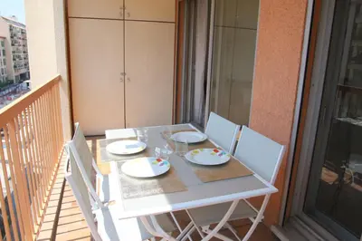a white table and chairs on a balcony at Le Renoir in Nice