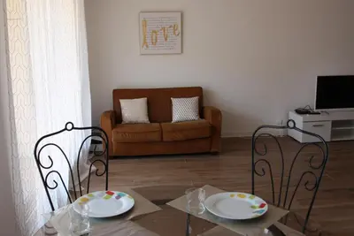 a living room with a table and chairs and a couch at Le Renoir in Nice