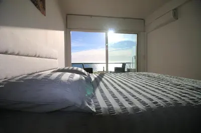 a bedroom with a large bed with a large window at Promenade des anglais Vue mer in Nice