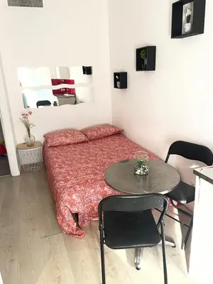 a small bedroom with a bed and a table at iNICE in Nice