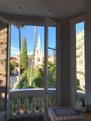 a balcony with a view of a building and palm trees at Dreamplace in Nice