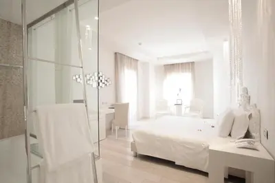 a living room with a white couch and chairs at Boscolo Nice Hotel & Spa in Nice