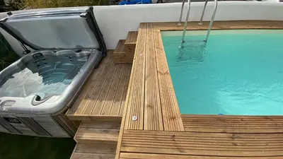 a hot tub sitting on a wooden deck next to a swimming pool at Hôtel La Villa Patricia - Charme et Tradition in Villefranche-sur-Mer