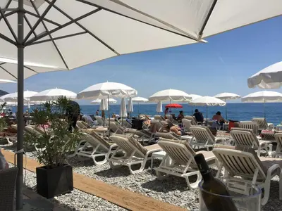 a group of chairs and umbrellas on a beach at Top Floor Apartment Santa Barbara in Nice