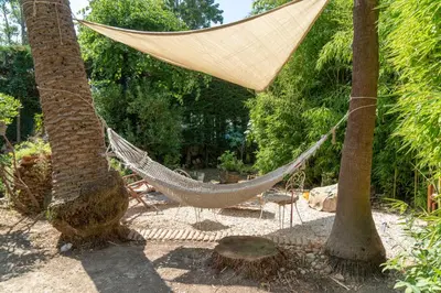 a hammock between two palm trees in a garden at Apartment Villa Anahit in Nice