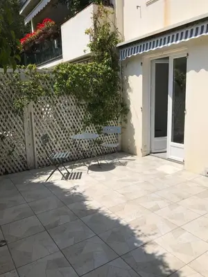 a patio with two chairs in front of a building at Au cœur de St Jean Cap Ferrat in Saint-Jean-Cap-Ferrat