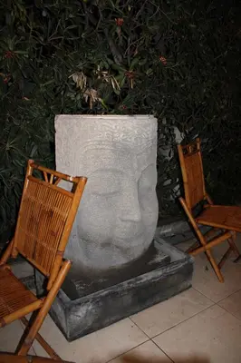 a statue of a head sitting next to two chairs at Hôtel La Villa des Oliviers in Cagnes-sur-Mer