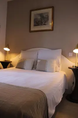 a bedroom with a large white bed with two lamps at Hôtel La Villa des Oliviers in Cagnes-sur-Mer