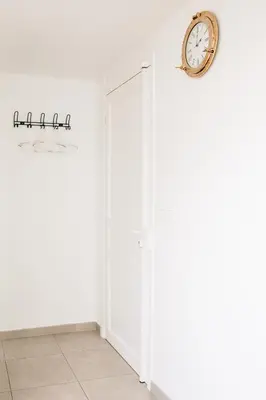 a white door with a clock on the wall at Adorable apartment in Nice downtown in Nice