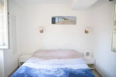 a bed in a white room with a picture on the wall at Sunny apartment in heart of Nice Old Town in Nice