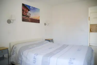 a white bed in a room with a picture on the wall at Sunny apartment in heart of Nice Old Town in Nice