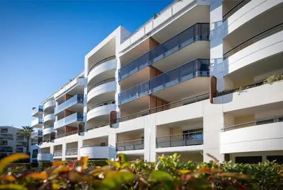 an apartment building with balconies and bushes at Nemea Appart Hotel Le Lido Cagnes sur Mer in Cagnes-sur-Mer