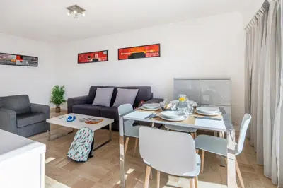 a living room with a table and a couch at Nemea Appart Hotel Le Lido Cagnes sur Mer in Cagnes-sur-Mer