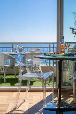 a glass table and chairs on a balcony with a view at 