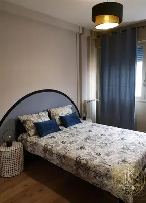 a bedroom with a large bed with blue pillows at Appartement Carré d'Or Vue sur Mer in Nice
