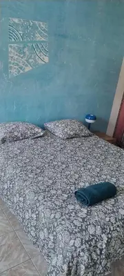 a bed with a blue pillow on top of it at Chez Brigitte Guesthouse in Nice