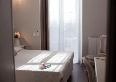 a bedroom with a bed with a box on it at Hôtel restaurant Oasis in Nice