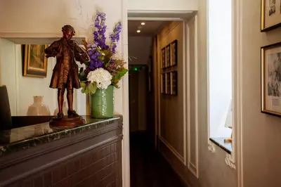 a statue of a man on a counter with a vase of flowers at Hôtel restaurant Oasis in Nice