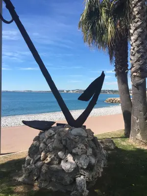 a statue of a bird sitting on a rock near the beach at O Phare du Cros in Cagnes-sur-Mer