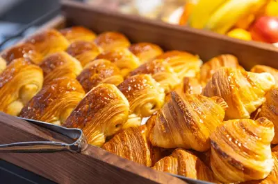 a bunch of pastries in a box with tongs at Maison Durante in Nice