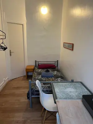 a small room with a bed and a table at Hôtel Lyonnais in Nice