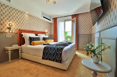 a bedroom with a large bed and a table at Hôtel Petit Palais in Nice