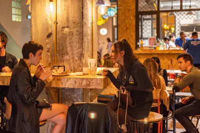 a group of people sitting at a table in a restaurant at Villa Saint Exupery Beach Hostel in Nice