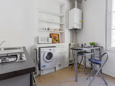 a kitchen with a washing machine and a table at Apartment Hérold-1 by Interhome in Nice
