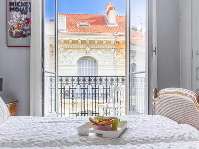 a plate of food sitting on a bed in front of a window at Apartment Le Concordia by Interhome in Nice