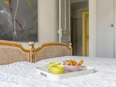 a tray with cups and a bowl of food on a bed at Apartment Le Concordia by Interhome in Nice