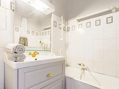 a white bathroom with a sink and a tub at Apartment Le Concordia by Interhome in Nice
