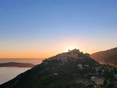 a castle on a hill with the sunset in the background at Apartment Les Balcons d'Eze-1 by Interhome in Èze