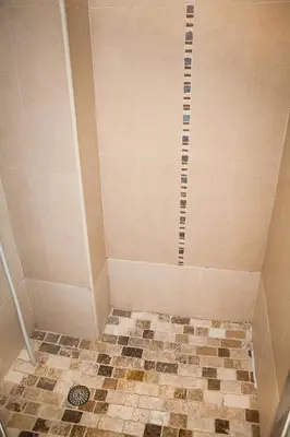 a bathroom with a shower with a tiled floor at Nice Riviera Sweet Home Chambres d'hotes in Nice