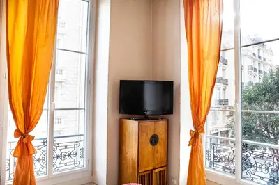 a tv sitting in a room with two windows at Nice Riviera Sweet Home Chambres d'hotes in Nice