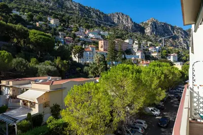 a view of a city with mountains in the background at Le Corot in Beaulieu-sur-Mer