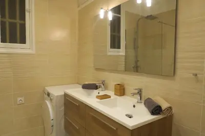 a bathroom with a sink and a toilet and a mirror at Carré d’Or Appt 4 Pièces moderne et spacieux in Nice