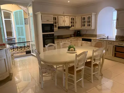 a kitchen with a white table and chairs in it at Seagulls in Villefranche-sur-Mer