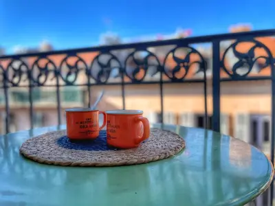 two orange cups sitting on a table on a balcony at Homelivia Av Jean Médecin in Nice