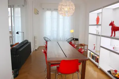 a dining room with a wooden table and red chairs at Le Maréchal in Nice